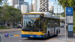 Route 130 Brisbane TransLink bus travelling toward Queen Street Station on a sunny day along a modern Brisbane city street.