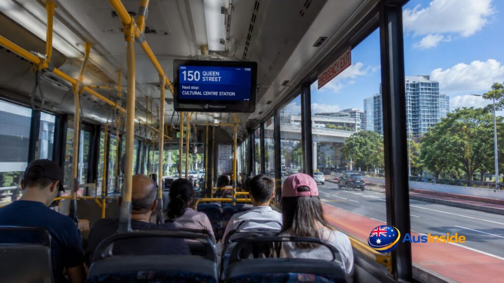Interior view of a Route 150 Brisbane Cityxpress bus with passengers seated as it travels toward Brisbane CBD on a sunny day.