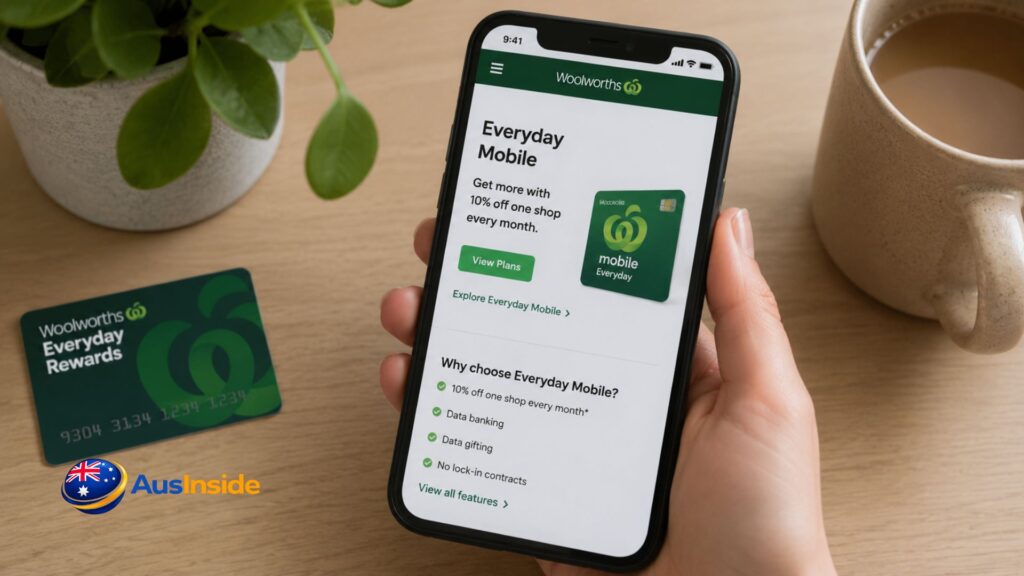 A person holding a smartphone displaying Woolworths Everyday Mobile plans beside an Everyday Rewards card and coffee mug on a wooden table.