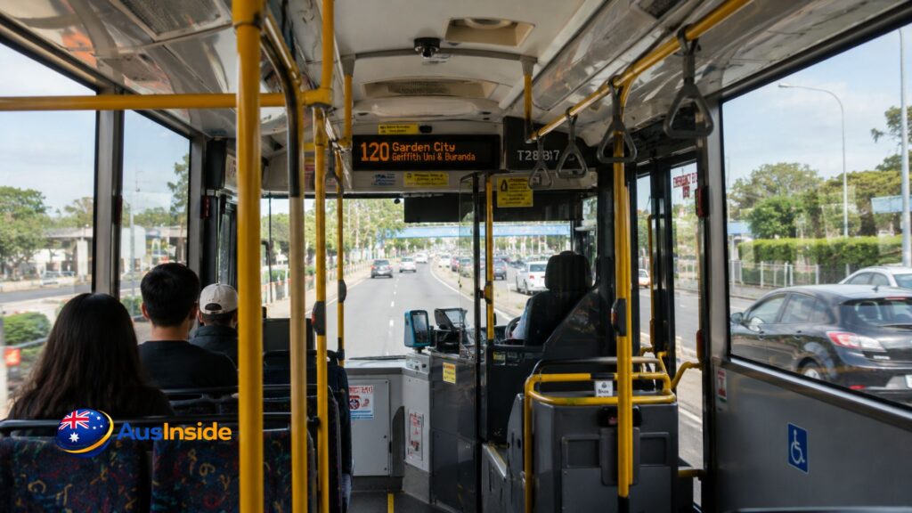 Interior view from inside a Route 120 Brisbane bus travelling along a city road with passengers seated and traffic visible through the front windshield.