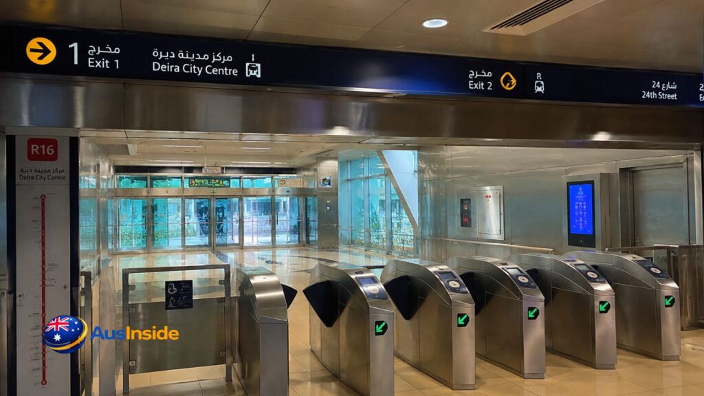 Deira City Centre Metro Station Exit 4 concourse with overhead Exit 1 and Exit 2 signs, R16 station marker and ticket gates.